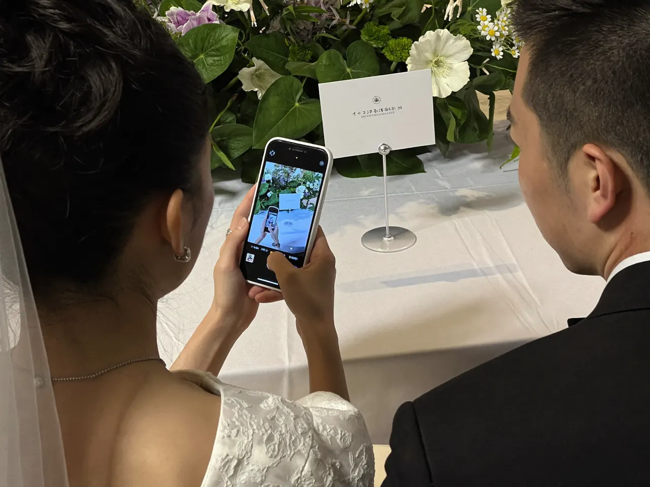 披露宴の席で、テーブルのカードにスマホをかざすゲスト